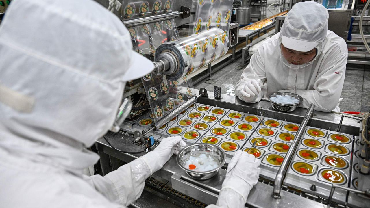 La foto muestra a empleados trabajando en una línea de producción de gelatina en una fábrica de alimentos en Suqian, en la provincia oriental china de Jiangsu. | Foto:STRINGER / AFP