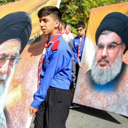 Miembros del movimiento scout afiliados a musulmanes chiítas marchan con grandes retratos que representan al líder supremo de Irán, el ayatolá Ali Khamenei y al líder del movimiento chií libanés Hezbollah, Hassan Nasrallah, durante el funeral de un miembro del movimiento chií libanés Hezbollah que murió el día anterior por la explosión de un dispositivo de comunicación, en Adloun, en el sur del Líbano. | Foto:Mahmoud Zayyat / AFP
