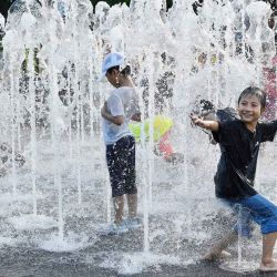 Niños se refrescan en una fuente en Gwanghwamun, Seúl, Corea del Sur. | Foto:Xinhua/Jun Hyosang