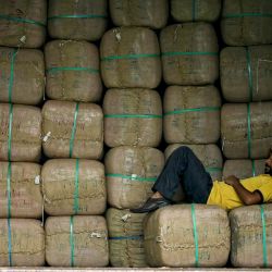 Un trabajador descansa sobre los suministros guardados en un camión de mercancías, a lo largo de una calle de Amritsar, India. | Foto:Narinder Nanu / AFP