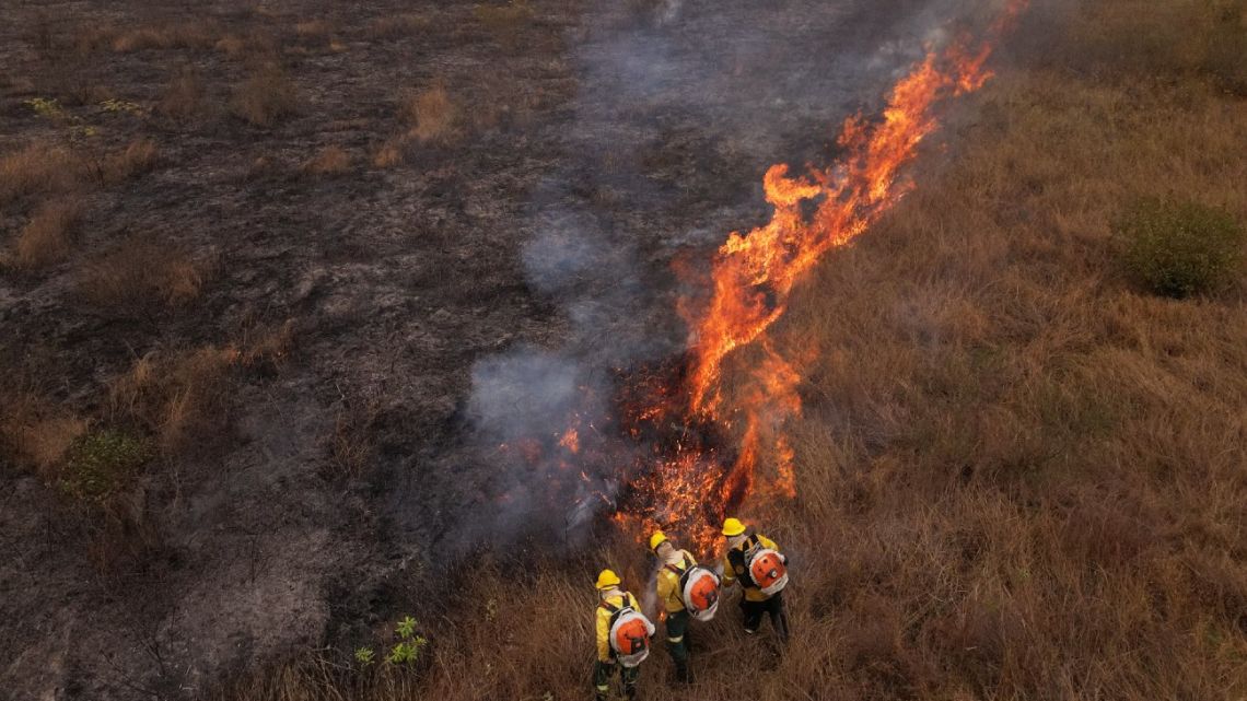 Aerial view of firefighters working on a fire outbreak in a rural area of Corumba, Mato Grosso do Sul State, Brazil on June 26, 2024. 