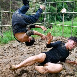 Esta fotografía muestra a Wang Tao entrenando con su compañero de equipo de lucha Chen Wenbin en el barro del bosque de montaña en Xingning, en la provincia de Guangdong, al sur de China. | Foto:Wang Zhao / AFP