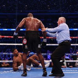El británico Anthony Joshua es derribado al suelo por el británico Daniel Dubois durante su combate de boxeo de peso pesado por el título mundial de la FIB en el estadio de Wembley en Londres. | Foto:Adrian Dennis / AFP