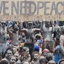 Los habitantes de la zona sostienen una pancarta mientras participan en una reunión cerca de la mina de oro de Porgera, en Porgera, en las tierras altas centrales de Papúa Nueva Guinea, casi una semana después de que llegaran refuerzos policiales a la zona en un intento de sofocar la violencia tribal que provocó el cierre de la mina de oro. Días de tiroteos entre cientos de guerreros tribales han dejado al menos 32 muertos en las inmediaciones de la minay cientos más han sido desplazados por la violencia. | Foto:AFP