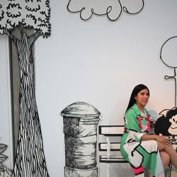 Una mujer posa para una fotografía en la exposición 'El mundo según Mafalda', un homenaje al 60 aniversario de la creación del caricaturista argentino Joaquín Salvador Lavado, conocido como Quino, en la Galería de Arte Nacional en Caracas, Venezuela. | Foto:Federico Parra / AFP