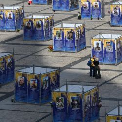 Una pareja mira carteles que representan a militares ucranianos muertos de la Brigada Azov en una exposición al aire libre en Kiev, en medio de la invasión rusa en Ucrania. | Foto:SERGEI SUPINSKY / AFP
