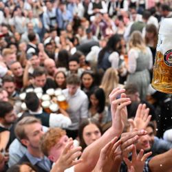 Los asistentes se pelean por una jarra de cerveza en el día de apertura del festival de cerveza Oktoberfest en Múnich, sur de Alemania. El festival de cerveza más grande del mundo, Oktoberfest, se celebra hasta el 6 de octubre de 2024. | Foto:KIRILL KUDRYAVTSEV / AFP