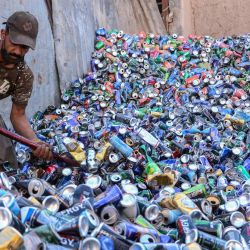 Un trabajador afgano clasifica latas de aluminio usadas en un depósito de reciclaje en Herat. | Foto:Mohsen Karimi / AFP