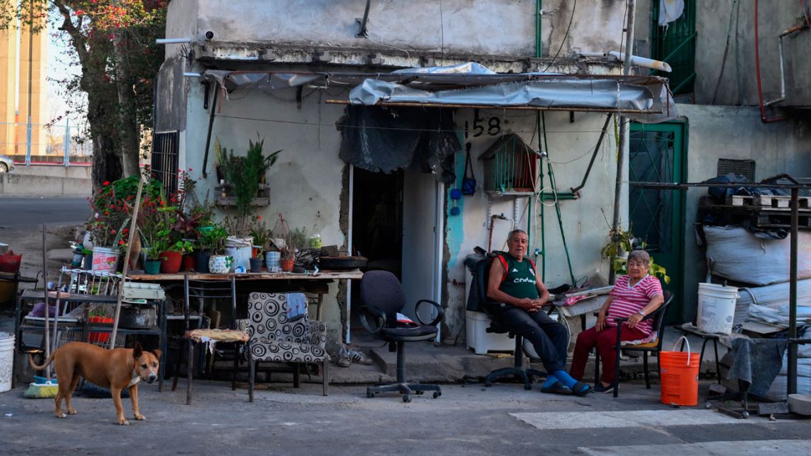 A couple is photographed in front of their house in the La Boca neighbourhood of Buenos Aires on September 20, 2024. 