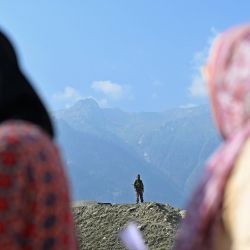Un miembro del personal de seguridad hace guardia mientras los votantes hacen cola para emitir su voto en un centro de votación durante la segunda fase de votación para las elecciones a la asamblea local, en Ganderbal. La Cachemira administrada por la India votó para elegir a su primer gobierno desde que Nueva Delhi eliminó el estatus semiautónomo del territorio del Himalaya, lo que desató una protesta generalizada en una región asolada por una insurgencia que dura décadas. | Foto:TAUSEEF MUSTAFA / AFP