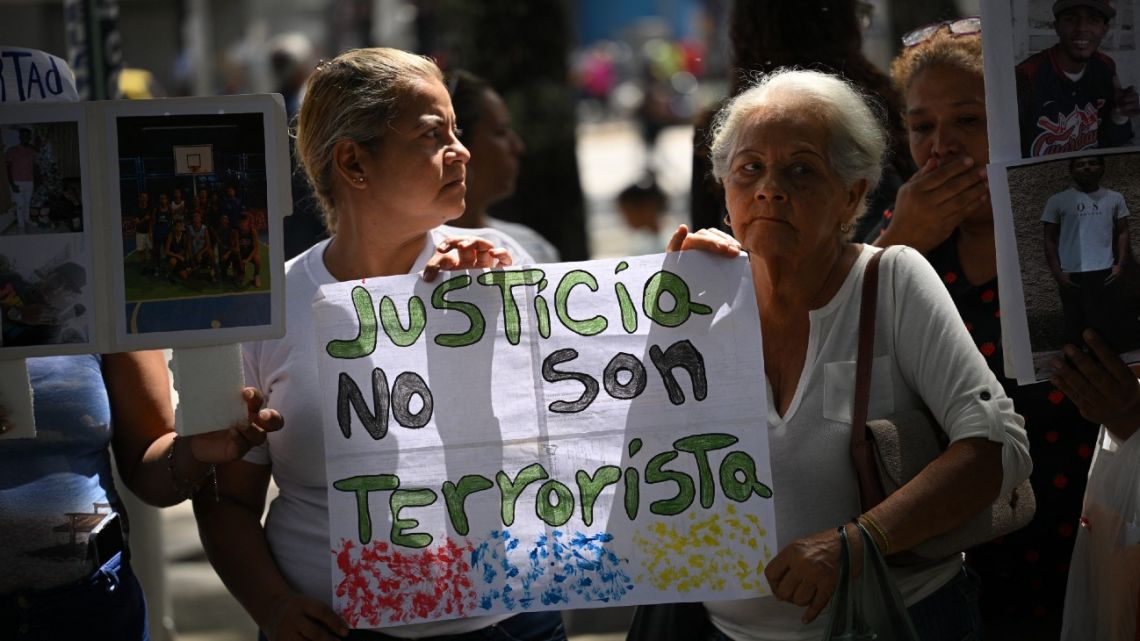 Women hold a sign claiming justice during a rally to demand the release of youngsters captured during protests after the disputed July 31 presidential election at the Public Prosecutor's Office in Caracas on September 26, 2024.