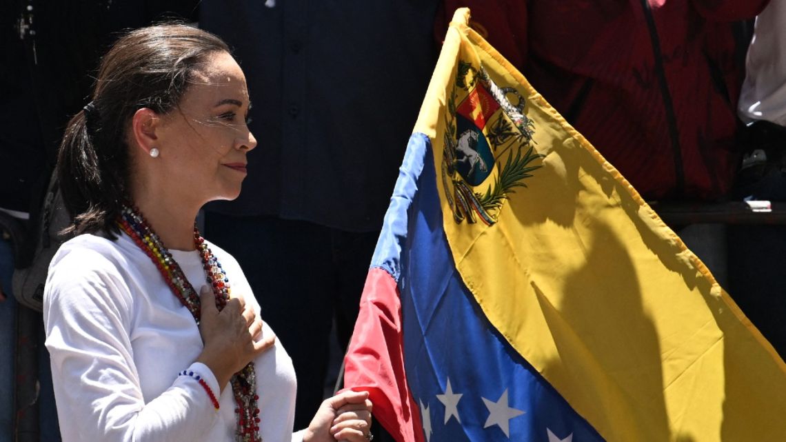 Venezuelan opposition leader María Corina Machado holds a Venezuelan national flag as she gestures from atop a truck during a demonstration to protest over the presidential election results, in Caracas on August 3, 2024. 