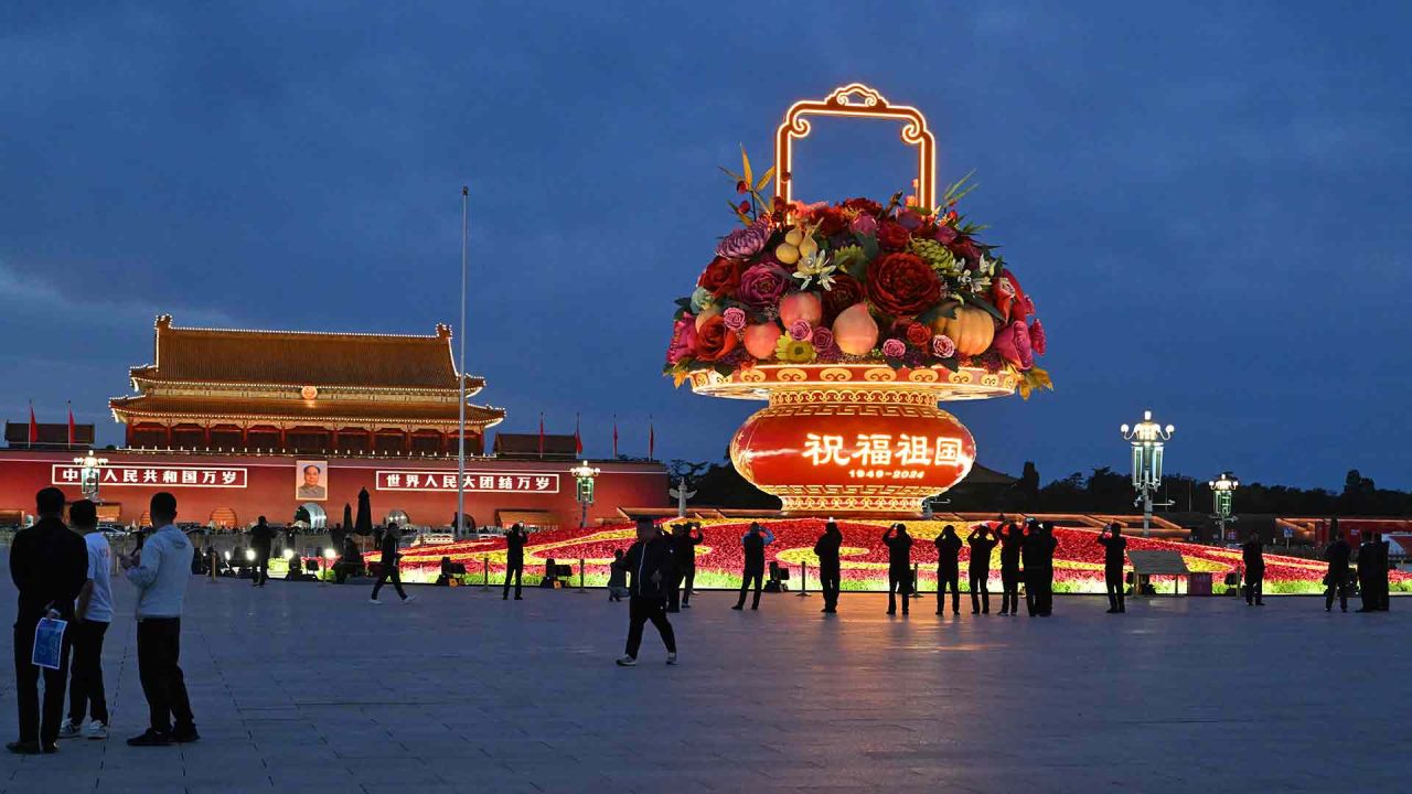 La gente se encuentra junto a una instalación en la Plaza de Tiananmen que conmemora el 75 aniversario de la República Popular China, en vísperas del Día Nacional en Beijing. Foto de ADEK BERRY / AFP | Foto:AFP