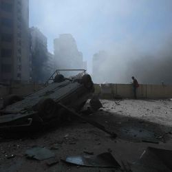 Un automóvil destruido mientras se elevan columnas de humo desde el lugar de un ataque aéreo israelí en un barrio de los suburbios del sur de Beirut. Foto de AFP | Foto:AFP