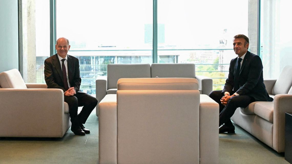 German Chancellor Olaf Scholz and French President Emmanuel Macron sit down for a meeting at the Chancellery in Berlin on October 2, 2024. 