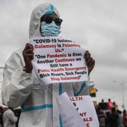 Un hombre sostiene carteles durante una protesta exigiendo la acción del gobierno contra la minería de oro ilegal y la liberación de un activista arrestado, en Accra. Foto de Nipah Dennis / AFP | Foto:AFP