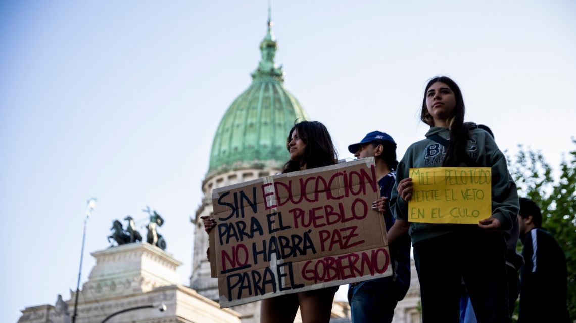 A demonstrator holds a sign that reads 'Without education for the people there will be no peace for the government' outside the National Congress in Buenos Aires on Wednesday.