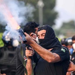 Un policía dispara proyectiles de gas lacrimógeno contra simpatizantes y activistas del partido Pakistan Tehreek-e-Insaf. Foto de Farooq NAEEM / AFP | Foto:AFP