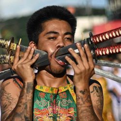 Un devoto del santuario Jor Soo Gong Naka con espadas atravesadas en la mejilla participa en una procesión durante el festival vegetariano anual en Phuket. Foto de MANAN VATSYAYANA / AFP | Foto:AFP