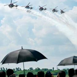 La gente se reúne para ver al equipo de exhibición de helicópteros Sarang de la Fuerza Aérea de la India, en Chennai. Foto de R. Satish BABU / AFP | Foto:AFP
