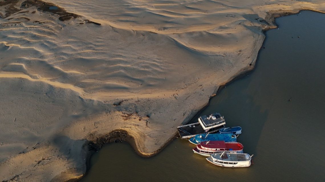 Boats are seen anchored on a sandbank on the Solimoes River in Manacapuru, Amazonas State, northern Brazil, on October 8, 2024. 