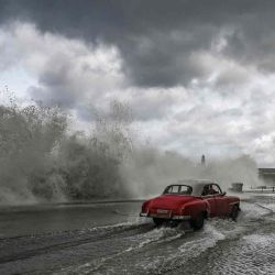 Un viejo automóvil estadounidense avanza entre las olas que se estrellan contra el malecón de La Habana debido al paso del huracán Milton. Foto de YAMIL LAGE / AFP | Foto:AFP