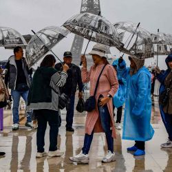 Los visitantes se protegen de la lluvia con paraguas en el Parvis des Droits de l'Homme en la Esplanade du Tocadero frente a la Torre Eiffel. Foto de Ludovic MARIN / AFP | Foto:AFP