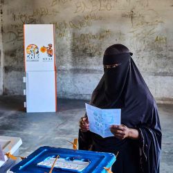 Una votante observa mientras un funcionario de un colegio electoral le muestra una papeleta en un colegio electoral de una escuela en Munhava, Beira, Mozambique. Foto de Zinyange Auntony / AFP | Foto:AFP