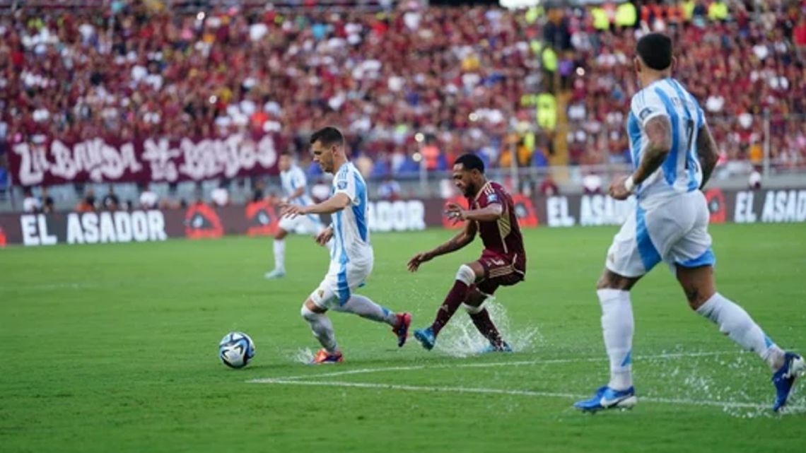 Argentina's players struggle on a waterlogged pitch against Venezuela.