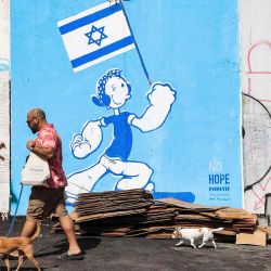 Olivia de la serie de dibujos animados Popeye, con brazos musculosos y sosteniendo una bandera israelí, en Tel Aviv. Foto de GIL COHEN-MAGEN / AFP | Foto:AFP