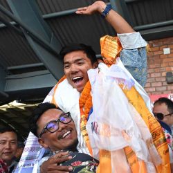 El alpinista nepalí Nima Rinji Sherpa saluda a su llegada al aeropuerto de Katmandú. Foto de Prakash MATHEMA / AFP | Foto:AFP