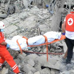Los paramédicos de la Cruz Roja Libanesa trasladan un cuerpo desenterrado de los escombros en el lugar de un ataque aéreo israelí que tuvo como objetivo la aldea de Aito. Foto de Fathi AL-MASRI / AFP | Foto:AFP