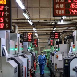 Un empleado trabaja en una línea de producción de anillos de pistón de aluminio en una fábrica que produce piezas de automóviles en Binzhou, China. Foto de AFP | Foto:AFP