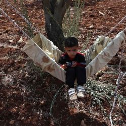 Un niño palestino se sienta en una hamaca durante la temporada de cosecha de aceitunas en la aldea de Qusra, al sur de Nablus. Foto de Zain JAAFAR / AFP | Foto:AFP