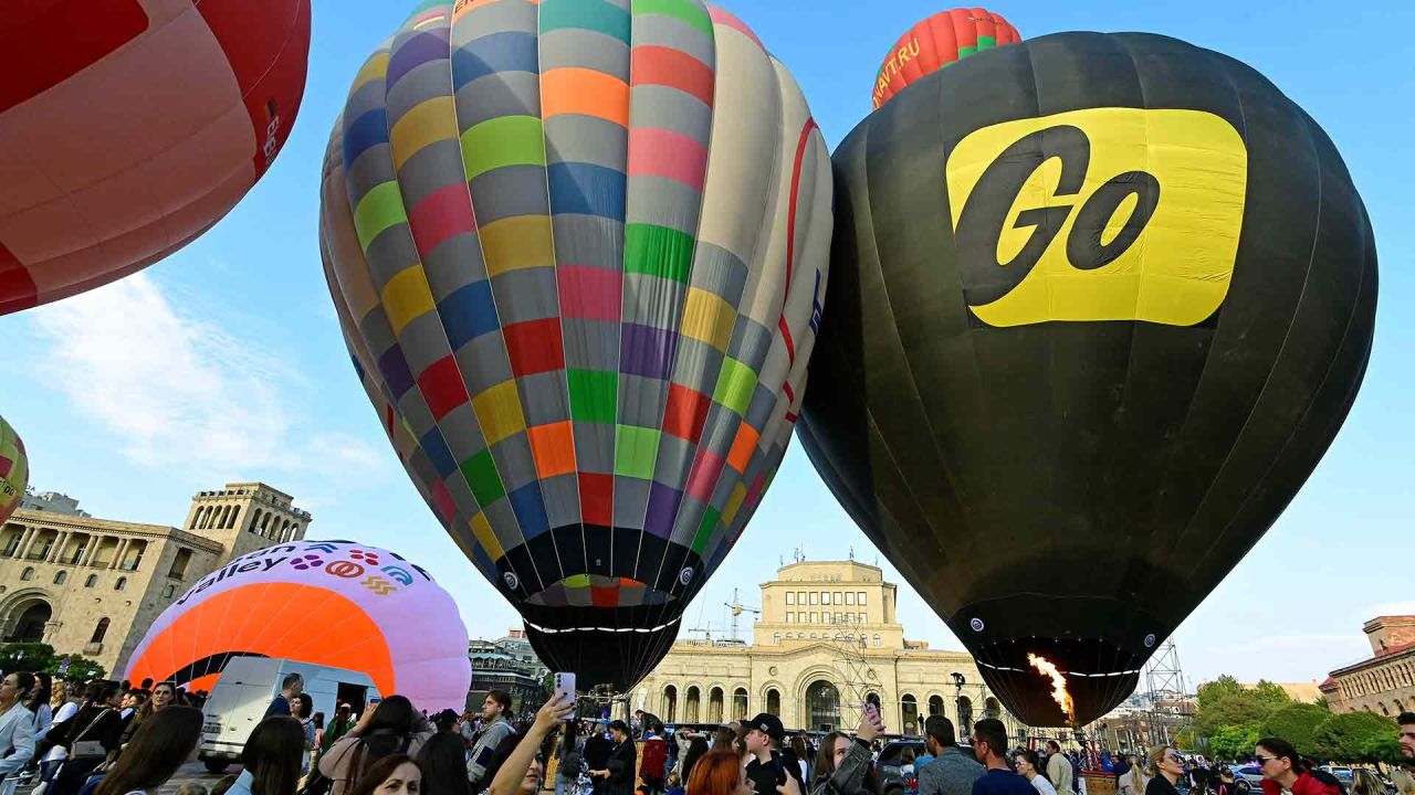 La gente toma fotografías mientras se encuentra bajo globos aerostáticos mientras se inflan en la Plaza de la República. Foto de KAREN MINASYAN / AFP | Foto:AFP