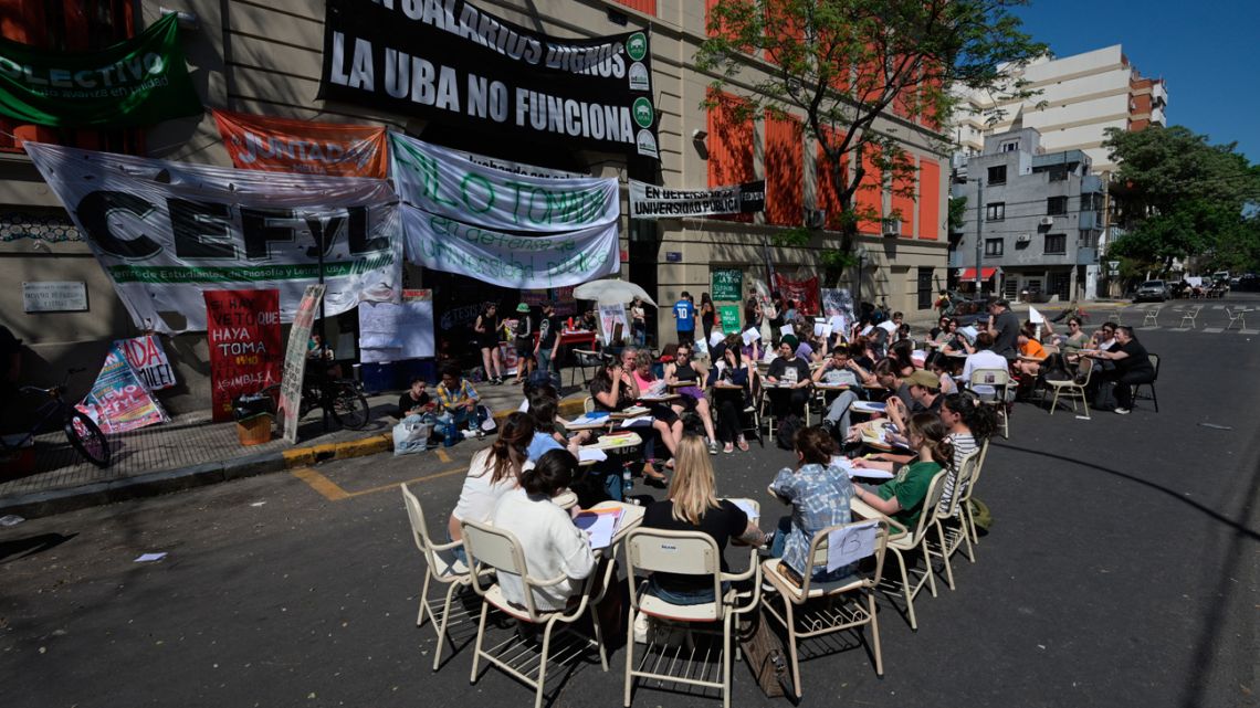 Students take a class in the street outside the Faculty of Philosophy and Letters of the University of Buenos Aires (UBA) in Buenos Aires on October 16, 2024.