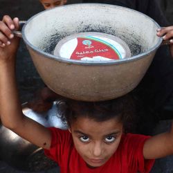 Una niña palestina desplazada lleva un contenedor de metal mientras hace fila para recibir raciones de comida en Deir al-Balah. Foto de Eyad BABA / AFP | Foto:AFP