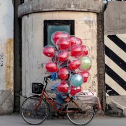 Un vendedor de globos afgano pasa junto al muro antiexplosiones en una calle de Kabul. Foto de Wakil KOHSAR / AFP | Foto:AFP