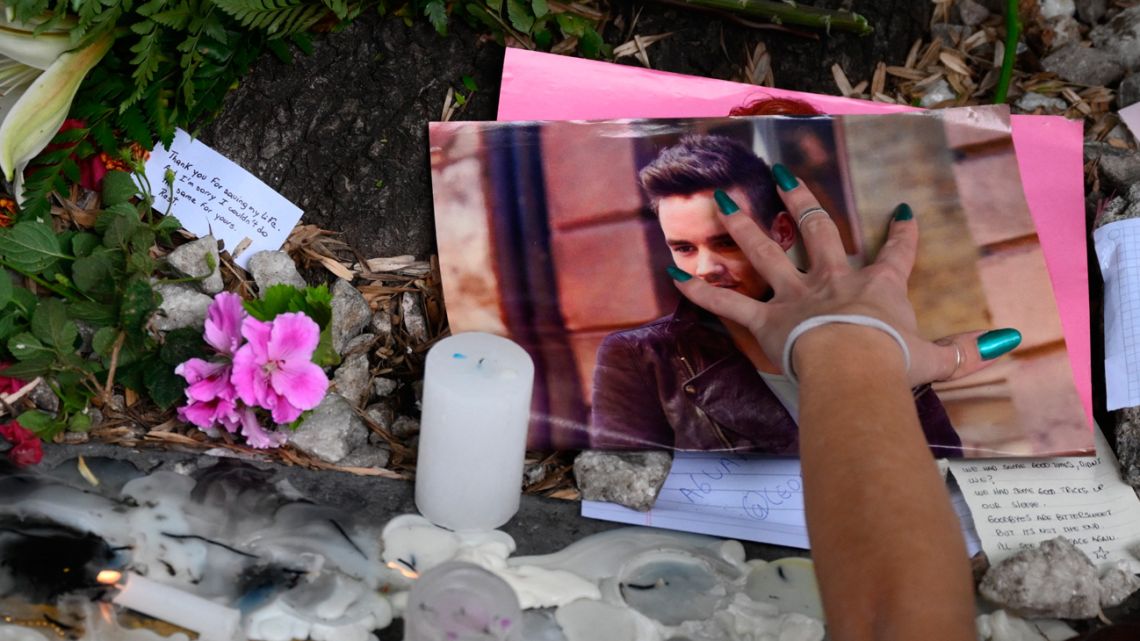 A fan pays tribute to British singer Liam Payne in front of the hotel where he died in Buenos Aires on October 17, 2024. Tributes poured in Thursday for British singer Liam Payne, a former member of the best-selling boy band One Direction, after he plunged to his death from the balcony of a Buenos Aires hotel. 