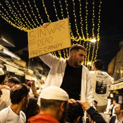 La gente sostiene carteles mientras celebra después de que el ejército israelí confirmara la muerte del líder de Hamas, Yahya Sinwar. Foto de JOHN WESSELS / AFP | Foto:AFP