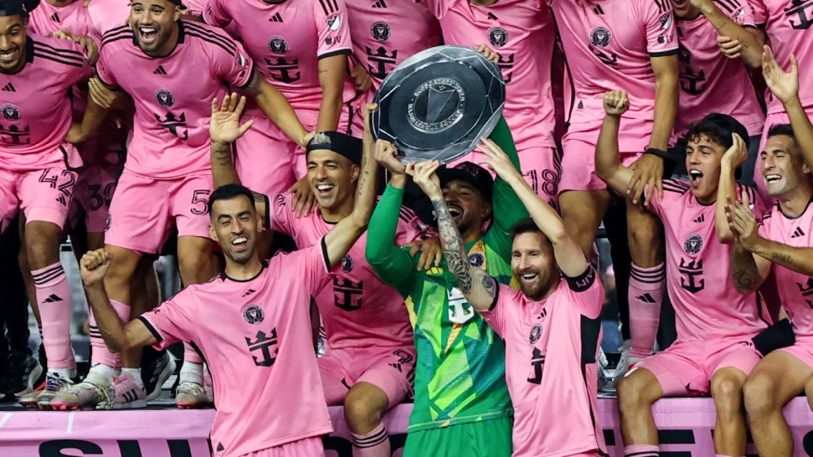 Inter Miami's Spanish midfielder Sergio Busquets, Uruguayan forward Luis Suárez, US goalkeeper Drake Callender and Argentine forward Lionel Messi hold the Supporters' Shield after the Major League Soccer (MLS) football match against New England Revolution at Chase Stadium in Fort Lauderdale, Florida, October 19, 2024. 