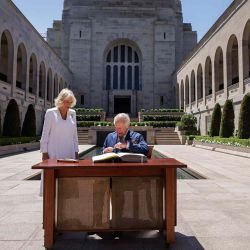 El rey Carlos III de Gran Bretaña firma un libro de visitas mientras la reina Camilla se encuentra junto a él en el Memorial de Guerra Australiano en Canberra. Foto de Brook Mitchell / AFP | Foto:AFP