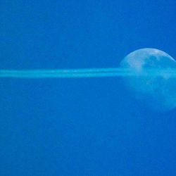 Las estelas de condensación de un avión de pasajeros se ven mientras vuela frente a la Luna en el cielo brumoso sobre Viena, Austria. Foto de JOE KLAMAR / AFP | Foto:AFP