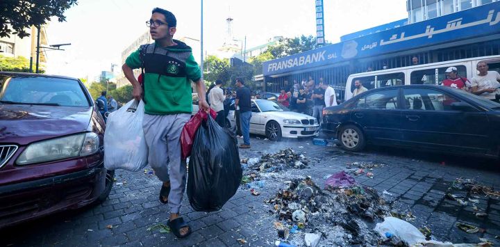 Las fuerzas de seguridad libanesas desalojan a personas desplazadas que huyeron de los bombardeos israelíes en los suburbios del sur de Beirut. Foto de IBRAHIM AMRO / AFP