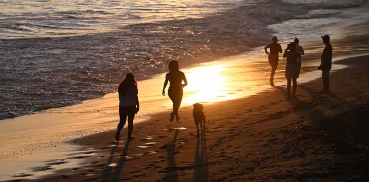  La gente disfruta en la playa El Sunzal antes del atardecer cerca del Puerto de La Libertad, El Salvador. Foto de Marvin RECINOS / AFP