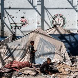 Unos niños buscan entre los escombros y las piedras junto a los refugios de tiendas de campaña en el patio de la escuela Shuhada. Foto de Eyad BABA / AFP | Foto:AFP