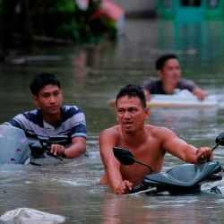 Los residentes empujan sus motocicletas por una calle inundada causada por las fuertes lluvias provocadas por la tormenta tropical Trami en la ciudad de Nag. Foto de ZALRIAN SAYAT / AFP | Foto:AFP