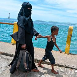 Una mujer y su hijo caminan tras ser rescatados de un barco que estuvo anclado una semana en la costa de Labuhan Haji. Foto de CHAIDEER MAHYUDDIN / AFP | Foto:AFP