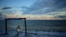 Una joven se balancea sobre las olas en Playa Blanca en Farallón, provincia de Coclé, a unos 100 km al suroeste de la ciudad de Panamá. Foto de MARTIN BERNETTI / AFP