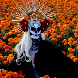 Una mujer vestida de 'Catrina' posa para una fotografía en medio de un campo de flores de cempazúchitl, como parte de los preparativos para la celebración del Día de Muertos en el Rancho San Juan Diego en Tlajomulco de Zúñiga, estado de Jalisco, México. El 2 de noviembre, México celebra el 'Día de los Muertos' para rendir homenaje a los amigos y familiares que han fallecido. | Foto:ULISES RUIZ / AFP